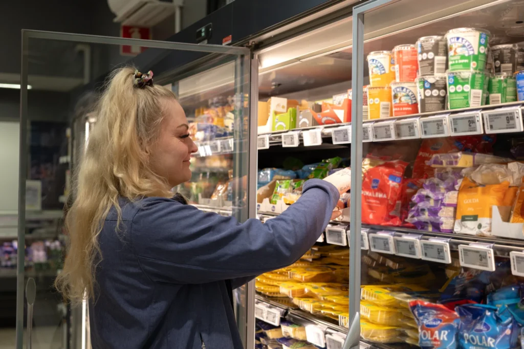 Marketpäällikkö Jenni Lehterä hyllyttää tuotteita S-market Merikarvian kylmähyllyyn.